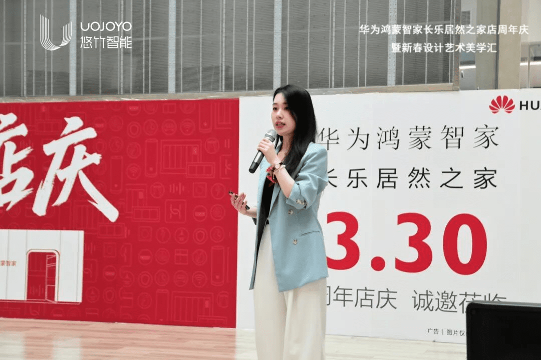 华为鸿蒙智家福建省培训老师穿着浅蓝色西装外套,手持麦克风在舞台上分享鸿蒙智家解决方案